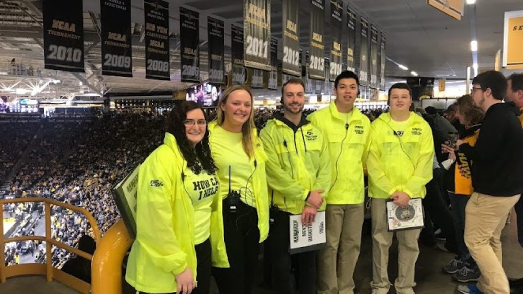 Students in yellow jackets at a sports arena